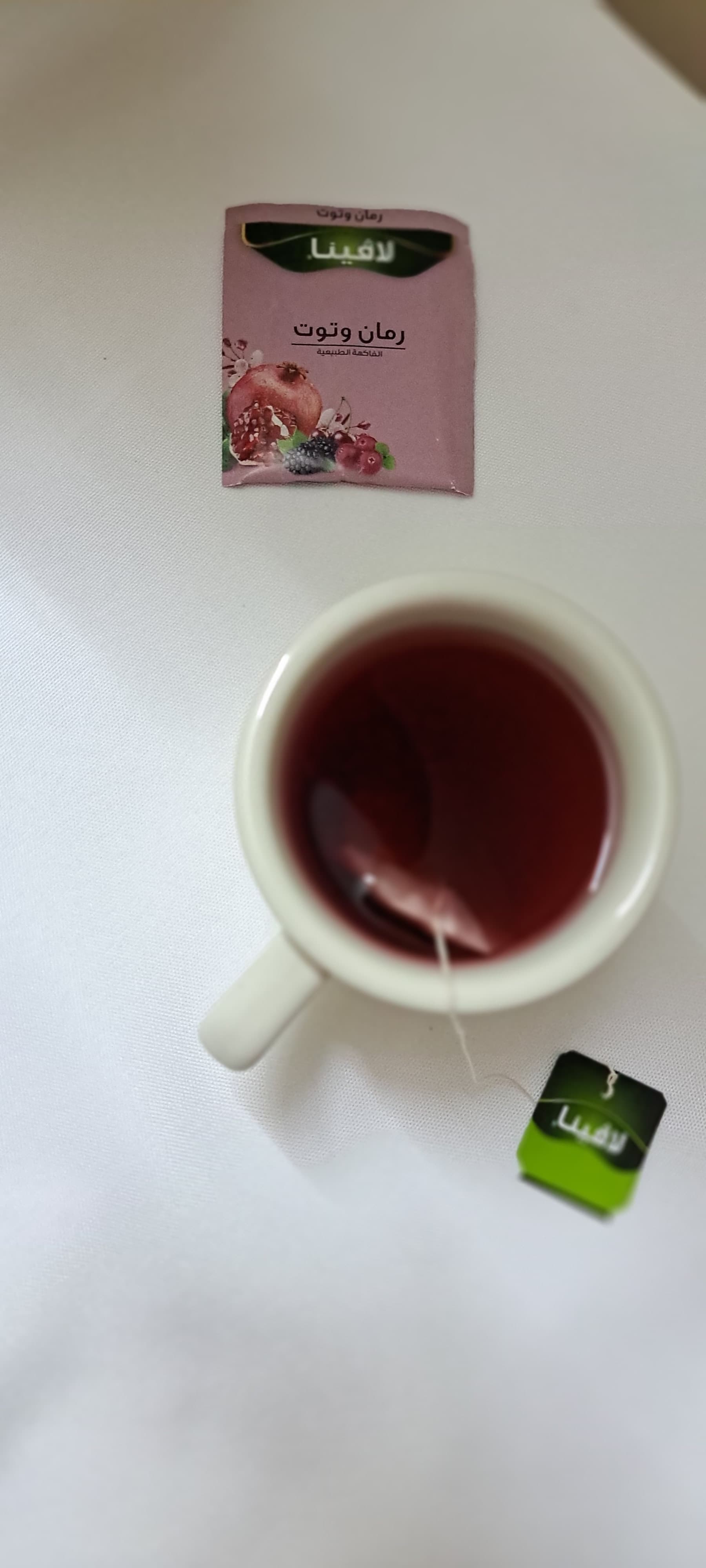 Image of a cup of Lavina pomegranate and berry tea with some fresh fruit